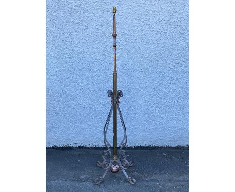 An Edwardian cast brass and wrought iron telescopic floor lamp, the ratcheted rise and fall stem over scroll iron decoration,