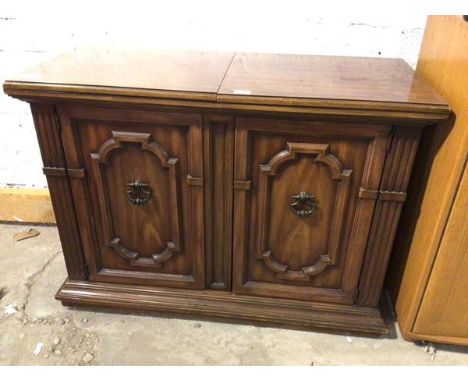 A modern side cabinet with fold out top above a pair of panel doors with single drawer and shelf to interior (one castor deta