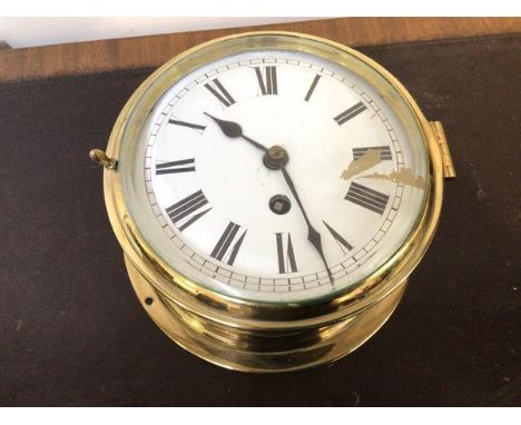 A late 19thc ship's bulkhead type clock, white enamel dial with roman chapter ring in a brass case with a bevel glazed bezel 