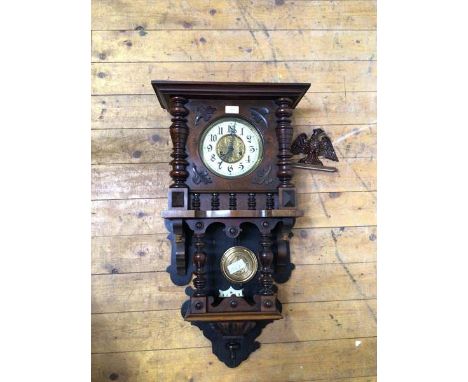 A late Victorian walnut cased regulator wall clock, the case surmounted by an associated eagle pediment, white ivorine dial w