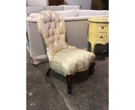 A Victorian spoon back salon chair upholstered in buttoned ivory striped silk fabric, raised on scroll carved cabriole suppor