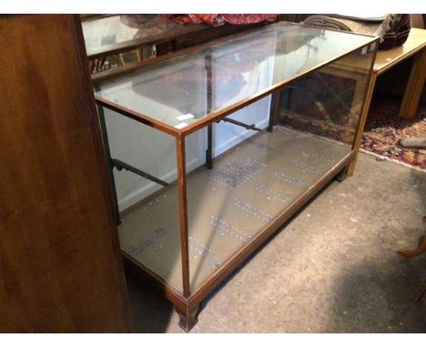 An early 20thc mahogany framed shop display counter with glazed top, sides and front, two panel doors to rear, interior fitte