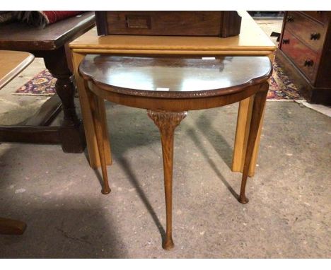 A 1930s/40s demi lune table, the top with an undulating moulded edge on cabriole supports terminating in pad feet, bears Mapl