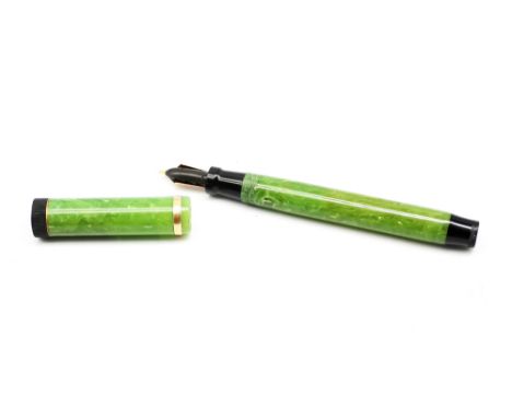 An early 20th Century Parker Duofold button filled fountain pen, with Jade green mottled barrel and cover, the cover with gil