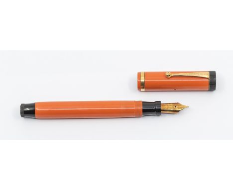 An early 20th Century Parker Duofold button filled fountain pen, with orange barrel and cover, the cover with gilt banding, t