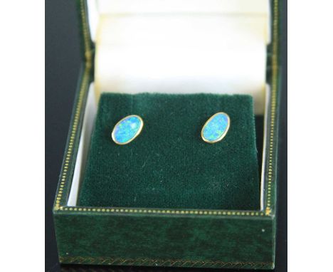 A pair of yellow metal opal set ear studs, the opal doublets each measuring approx 4.2 x 7mm, mounts stamped 14k