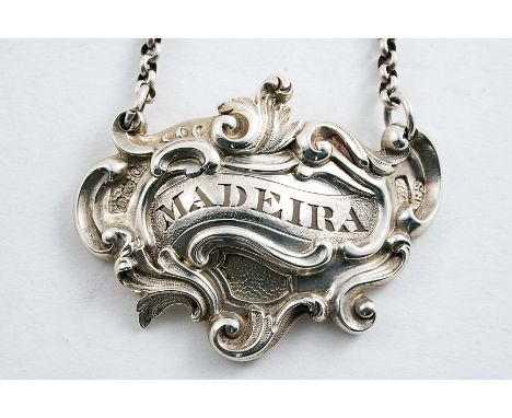A WILLIAM IV CAST WINE LABEL of asymmetrical form with scroll, foliage and chased reserves of matted work, pierced "MADEIRA",