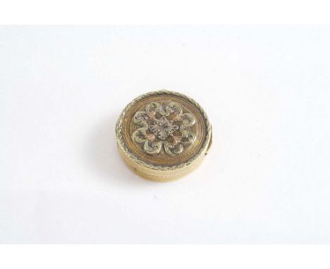 A GOLD VINAIGRETTE engine turned with pierced grille, the cover with foliate scrolls in three colours;   3 cms diameter