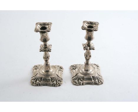 A PAIR OF LATE VICTORIAN TAPERSTICKS on shaped square bases with knopped columns and shell decoration at the corners, detacha