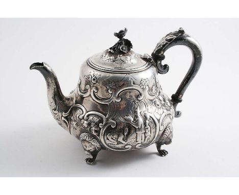 A VICTORIAN SMALL EMBOSSED TEA POT on four lion mask feet, with a baluster body, a leaf-capped scroll handle and a flower fin