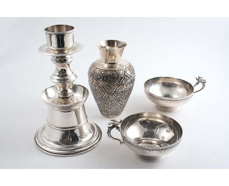 FOUR LATE 20TH CENTURY MIDDLE EASTERN ITEMS:- A vase with chased decoration, a pricket candlestick and two cups with bird & s