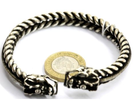 White metal Tibetan silver twisted bangle with dragon head finials, D: 7 cm approximately. P&amp;P Group 1 (£14+VAT for the f