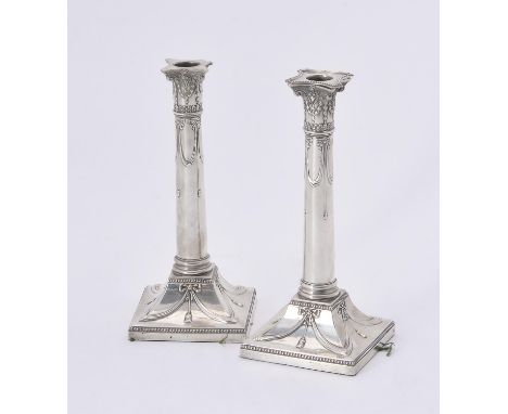 
	
		A pair of Edwardian silver candlesticks by Thomas Bradbury &amp; Sons, London 1903, one with a beaded sconce, the capita