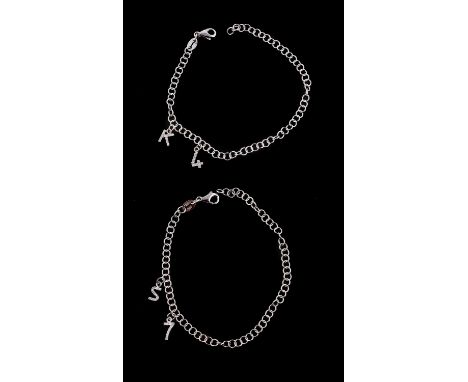 
	
		Two charm bracelets, each with belcher links suspending two diamond set charms, one with a K and 4, the other with a S a