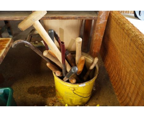 A metal bucket containing various tools