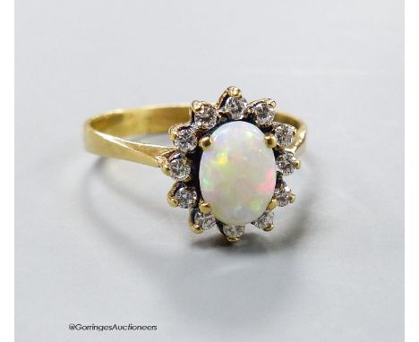   A modern yellow metal, white opal and diamond set oval cluster ring, size S, gross 4 grams.