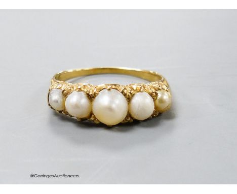   A yellow metal and graduated five stone split pearl half hoop ring, size R, gross weight 3.8 grams.