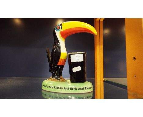 A Carlton-ware Guinness lamp base 'How Grand to be a Toucan Just Think What Toucan Can Do'   Missing lamp electrics and shade