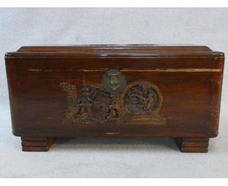 A mid century Chinese carved camphorwood trunk with inset carved carrying handles. H.41 W.77 D.37cm 
