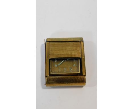A gilt metal Swiss Made travel clock with engine turned decoration. Luminous numerals and hands. Inscribed to the back, with 