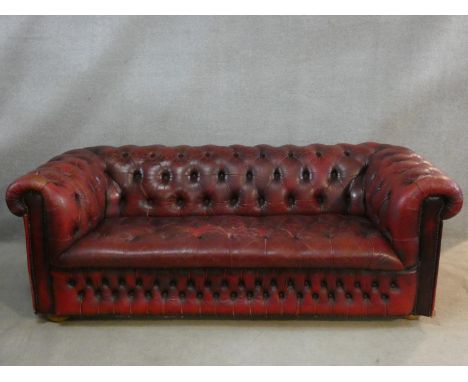 A Chesterfield sofa in buttoned leather upholstery. H.70 L.190 D.90cm (worn in places as photographed). 