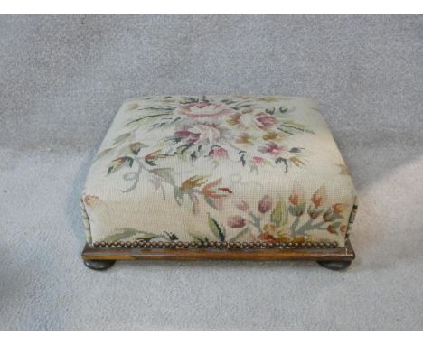 A 19th century mahogany footstool in tapestry upholstery on bun feet. H.16 L.44.5 W.44.5cm 