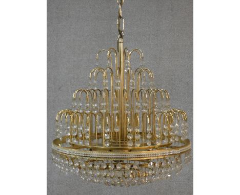A brass framed four tier wedding cake style chandelier with crystal drops. H.50 D.43cm 