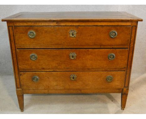 A 19th century French Provincial oak commode chest of three long drawers on square tapering supports. H.80 W.99 D.46cm 