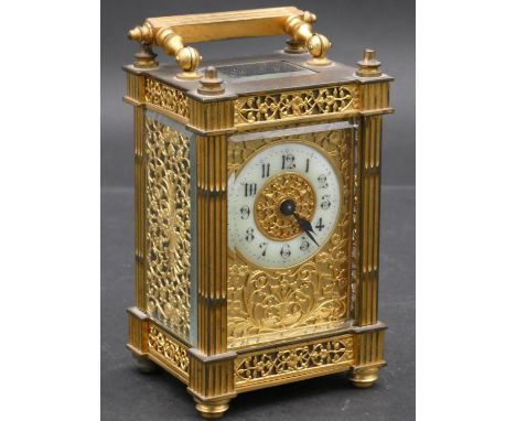 A C.1900 gilt brass cased carriage clock with white enamel dial and Arabic numerals with pierced foliate decoration to the fa