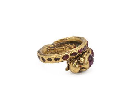  Yellow metal and ruby Siam ring, early 20th Century. Set with various cabochon cut rubies, in the form of a coiled dragon wi