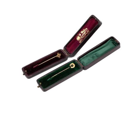Two 15ct gold hallmarked stick pins, one in the form of a horseshoe and the other set with a ruby, both in tooled leather box