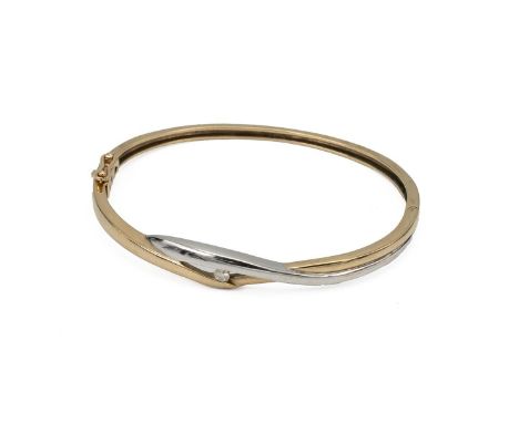 Yellow and white metal bangle, set with a single brilliant cut white stone, marked '9ct', tested as 9ct gold, 13 grams.