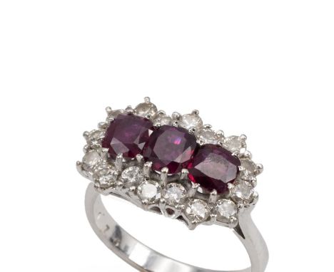 18ct white gold ruby and diamond dress ring, set with three rubies, each approx 0.5 carats, surrounded by 16 cut near matched