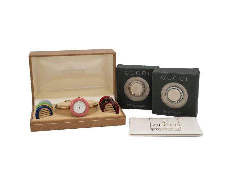 Ladies Gucci 11/12 gold tone bangle watch with colour change bezels. White dial with 11 coloured interchangeable bezels and t