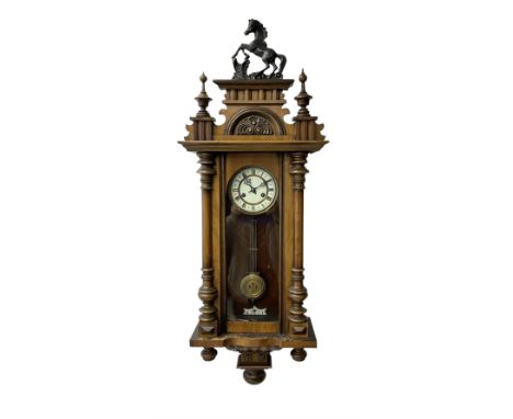 19th century 8-day German Vienna style wall clock, in a walnut case with a decorative pediment and turned finials, fully glaz