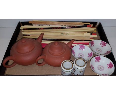 Two small terracotta Chinese green tea teapots, a pair of chopstick holders, various chopsticks and three Chinese tea bowls 