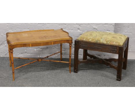 A Reprodux walnut coffee table (slight damage) along with a carved oak upholstered stool.