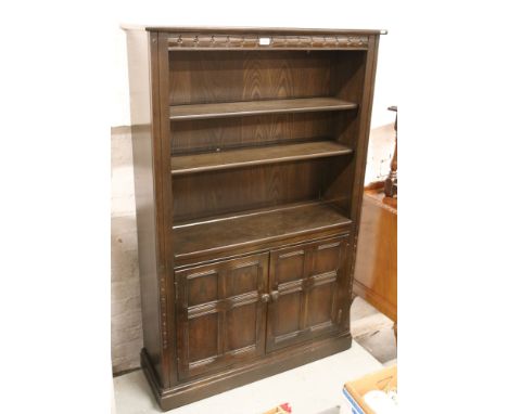 A black Ercol bookcase over cupboard base.