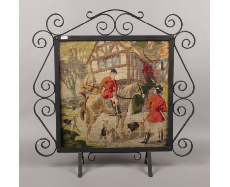 A woolwork firescreen depicting a hunting scene in iron frame.