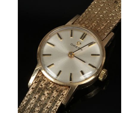 A ladies 9ct gold Omega manual wristwatch with satin dial and applied baton markers. (Total weight 30.44g)