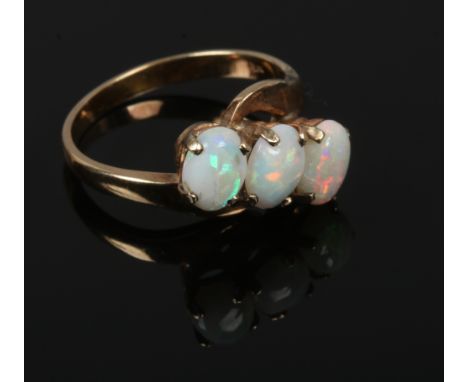 A 14ct gold three stone opal crossover ring, size N.