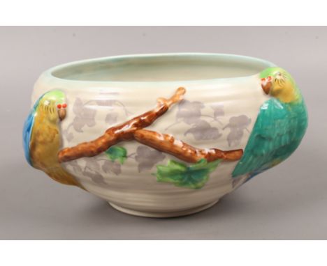 A Clarice Cliff fruit bowl decorated with painted parrots.