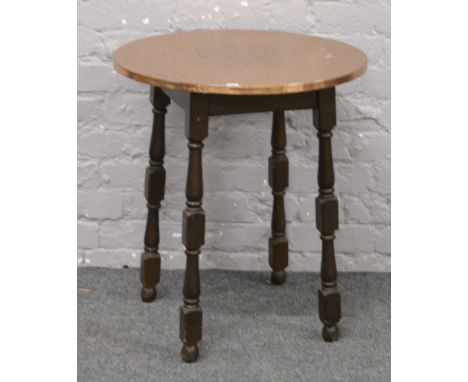 A hammered copper top occasional table with turned mahogany base.