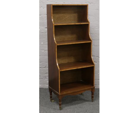 A mahogany waterfall open bookcase on turned castered supports. (Height 126cm)Condition report intended as a guide only.One c