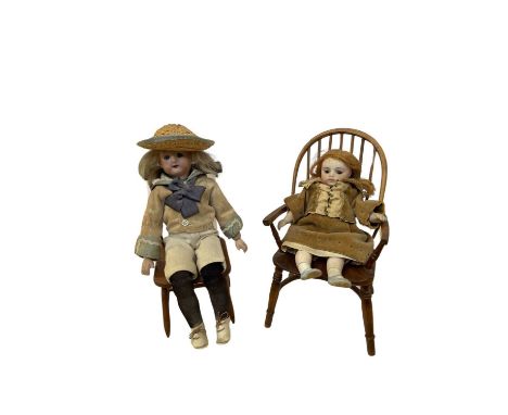 A pair of small bisque head dolls on wooden stick back chairs.One unmarked, the other a Max Oscar Arnold-Welsch, marked to re