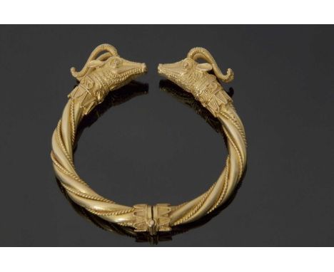 High grade yellow metal hinged bangle in Etruscan style, the plain polished and bead twist frame with ram's head terminals, 7