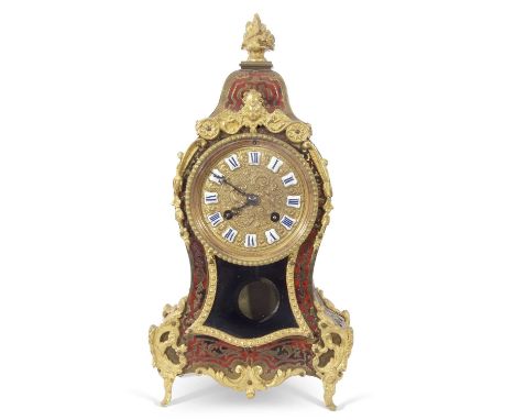 A boule mantel clock of shaped form, the case fitted with floral finial, the body applied with foliate brass detail, the pres