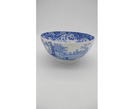 A 19th century large blue and white transfer printed ceramic bowl with unglazed foot. Interior with a landscape scene with sh