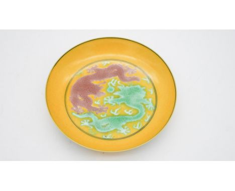 A Kangxi style porcelain golden-yellow ground dragon dish, six-character Guangxu mark. Grape decoration to the reverse. Diame