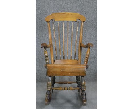 A 19th century beech and pine stick back rocking chair. 